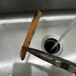 Pulling a popsicle stick out of a disposal.