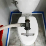 Removing a leaking toilet supply stop.