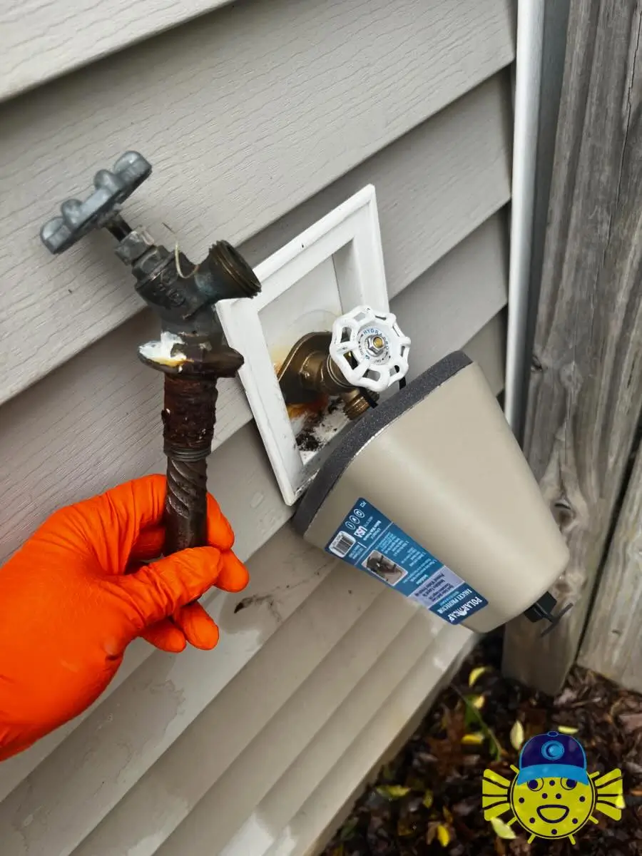 Old corroded outdoor hose bib held next to a newly installed frost-free spigot with an insulated cover by Swell Guy Plumbing in Hanahan, SC.