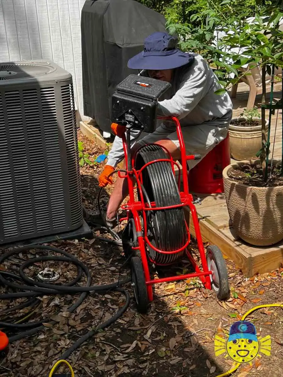 Swell Guy Plumbing technician performing a sewer line camera inspection outdoors in Charleston, SC.