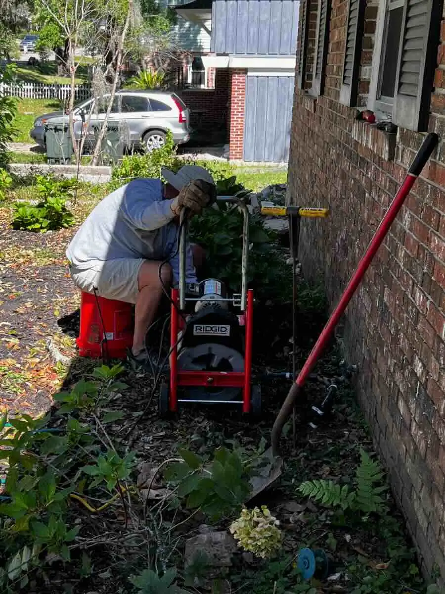 Swell Guy Plumbing technician operating drain clearing equipment outside a home in Goose Creek, SC