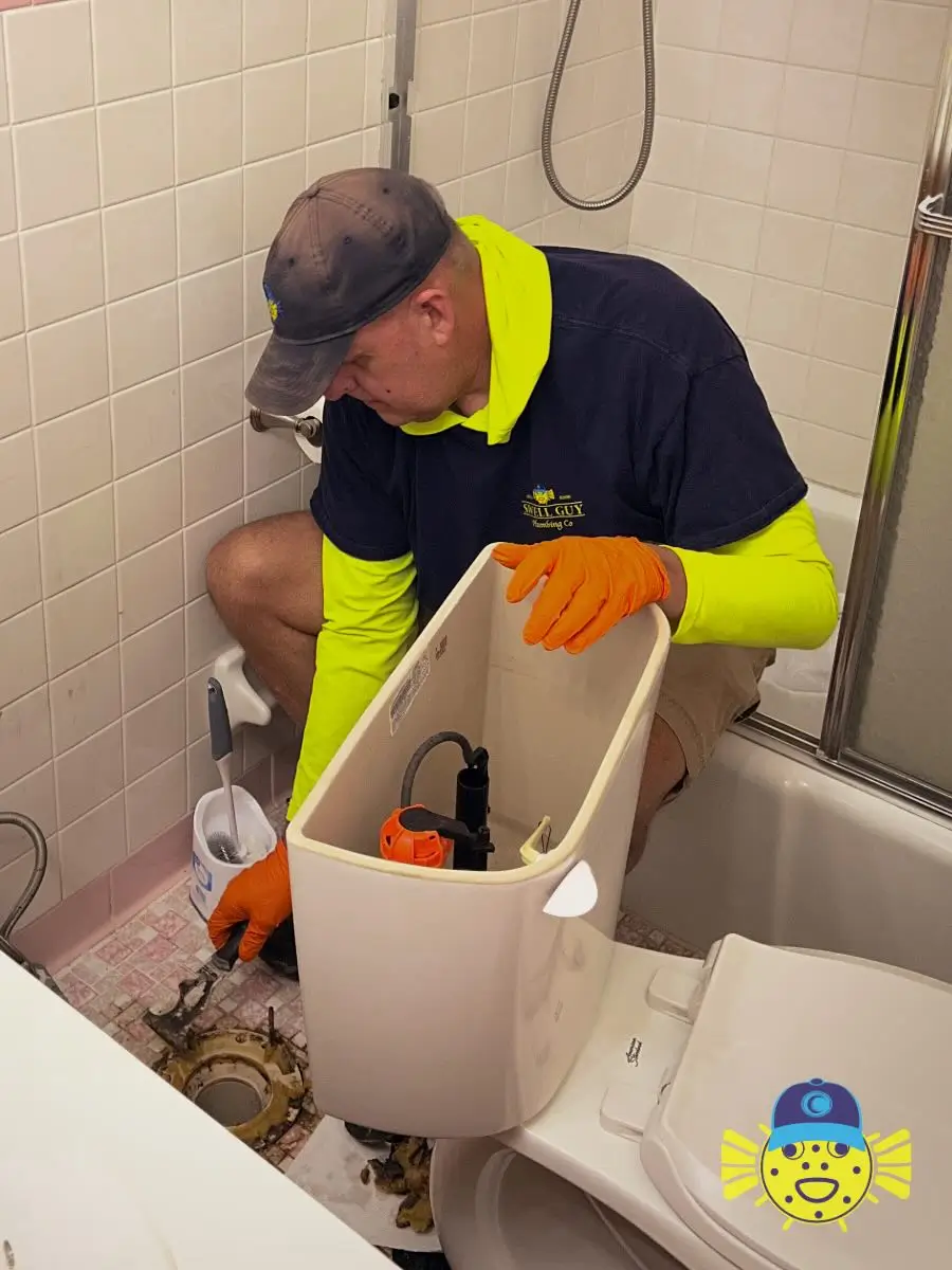 Swell Guy Plumbing technician scraping an old toilet wax ring seal off the floor flange during a replacement in Moncks Corner, SC.