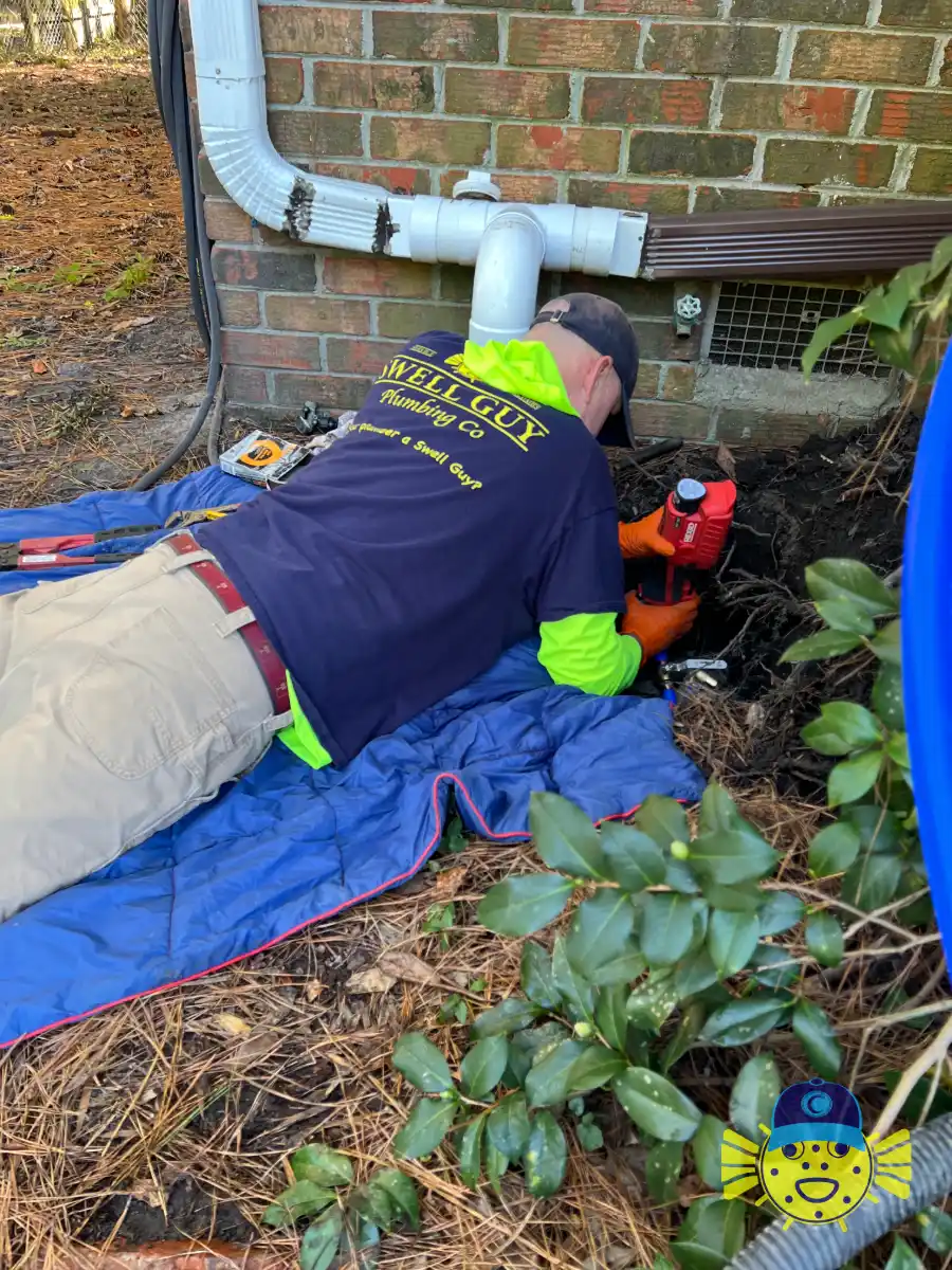 Swell Guy Plumbing technician repairing a main water line leak at the foundation of a house in Summerville, SC.